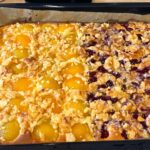 Cuca alema original assada com metade pessego e metade cereja em calda, streusel crocante por cima