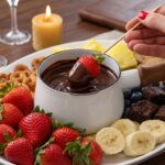 fondue de chocolate cremoso servido com morangos e marshmallow em rechaud